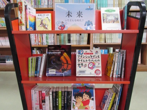 カートの上に本が並べられている写真。「未来ってどんな時代？」というポスターを掲示しています。
