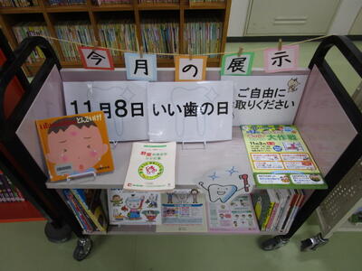 本を載せたカートの写真。「いい歯の日」というポスターが掲示されています。