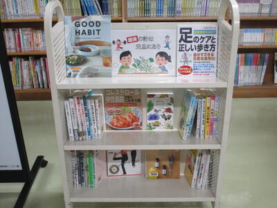 本を載せたカートの写真。「健康の計は元旦にあり」という掲示がなされています。