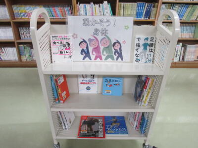 本を載せたカートの写真。「動かそう！　身体」という掲示がなされています。