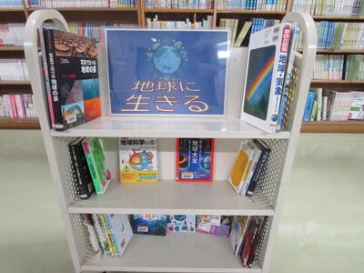 本を載せたカートの写真。「地球に生きる」という掲示がなされています。