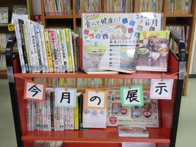 本を載せたカートの写真。「食育月間」「食べて健康に！」という掲示がなされています。