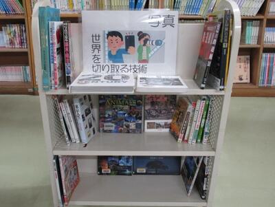 本を載せたカートの写真。「写真　世界を切り取る技術」という掲示がなされています。