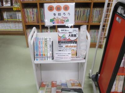 本を載せたカートの写真。「認知症を知ろう」という掲示がなされています。