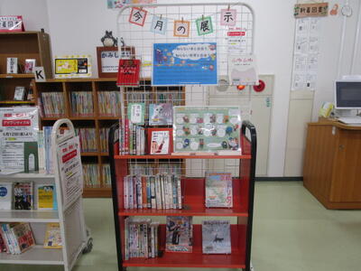 本を載せたカートの写真。「今月の展示」「知らない本と出会う、知らない世界と出会う」という掲示がなされています。